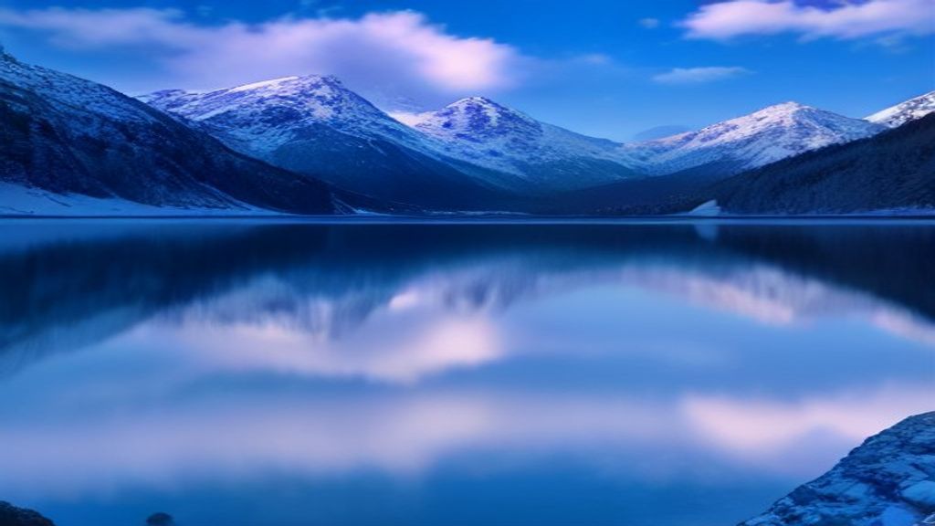 Crystal-clear Alpine Lake Reflecting Snow-covered Mountains Beneath A Nature wallpaper